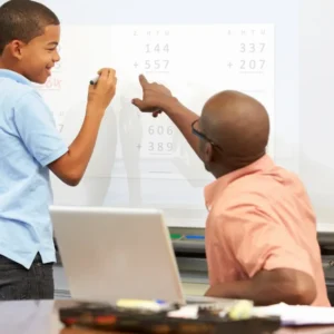 A man and boy are pointing at a whiteboard