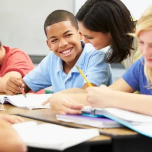A group of students sitting at a table with papers.