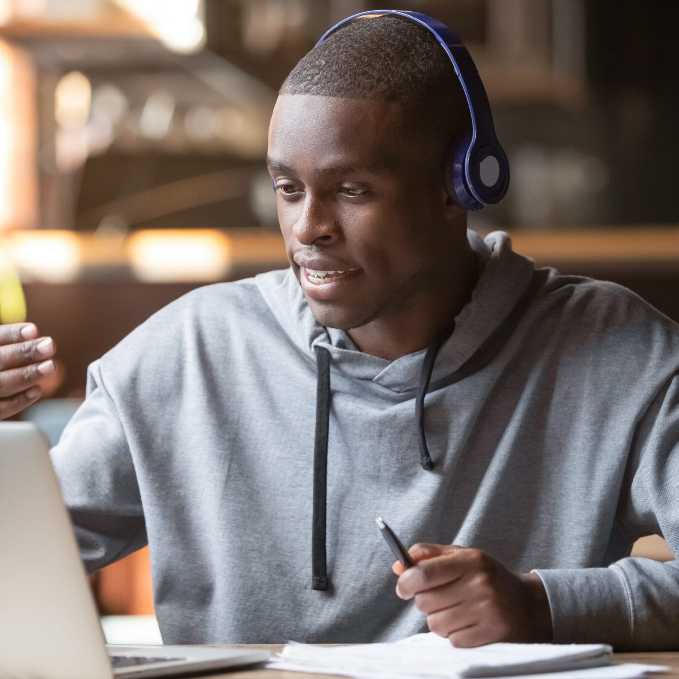 A man wearing headphones and using a laptop
