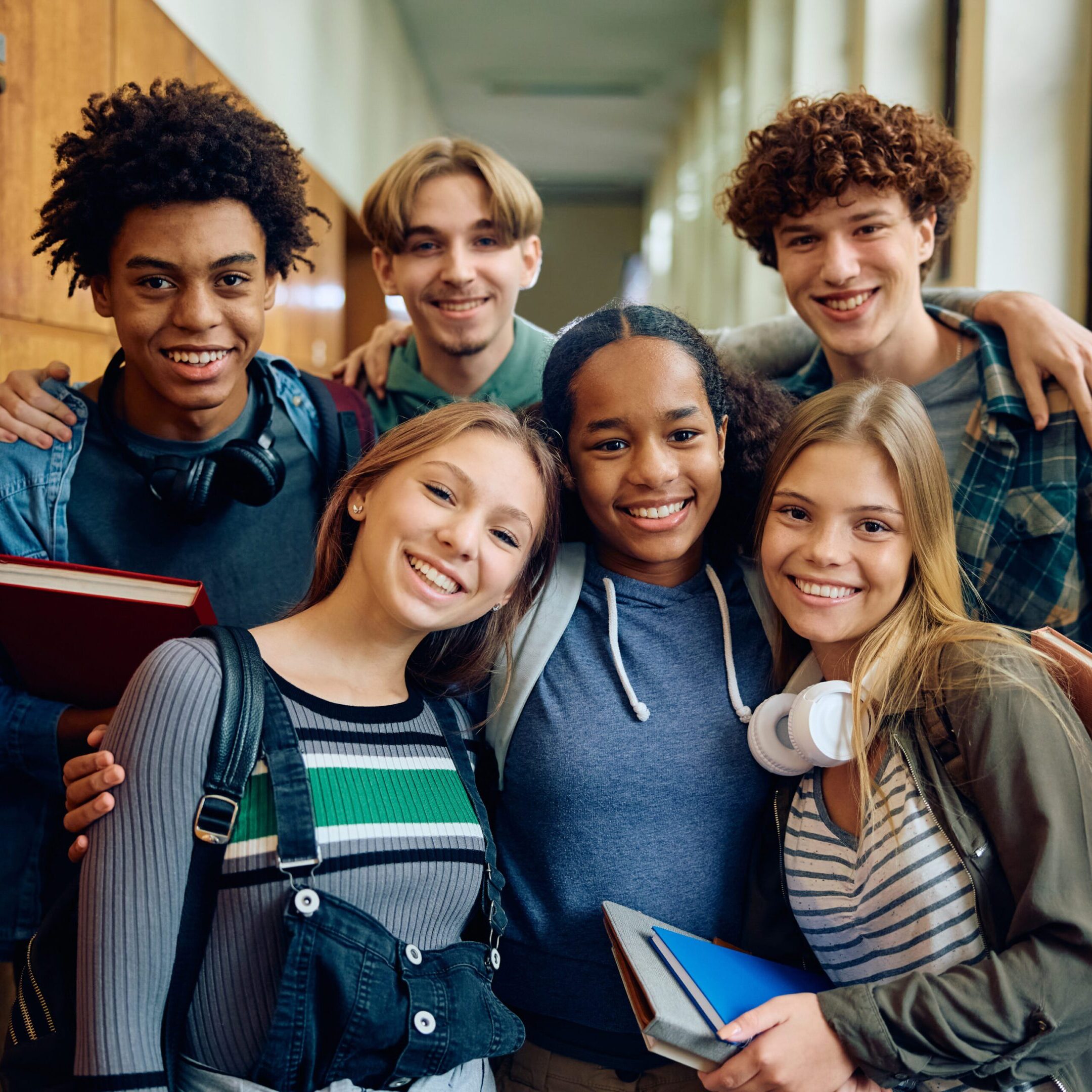A group of young people standing together in a hallway.